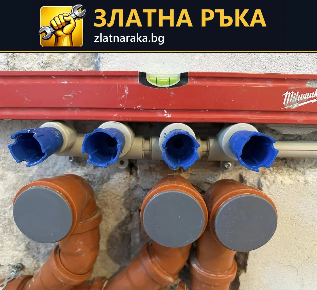 Четири защитени водни извода са подредени над три широки канализационни тръби в разкрита стена