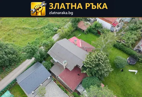 Поглед от въздуха към жилищни покриви в различни цветове сред дървета и дворни площи