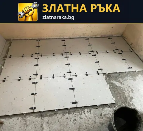 Частично покрит под със светли квадратни плочки и черни нивелиращи елементи.