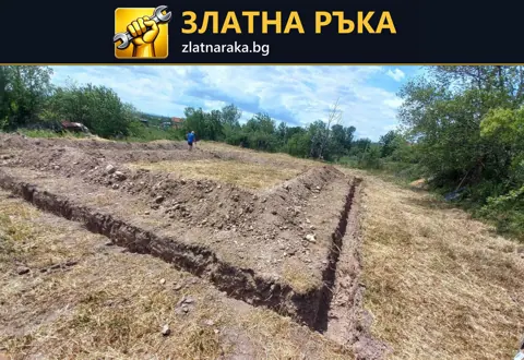 Пресни прави изкопи очертават голям правоъгълник в разчистен терен до дървета и ниска растителност