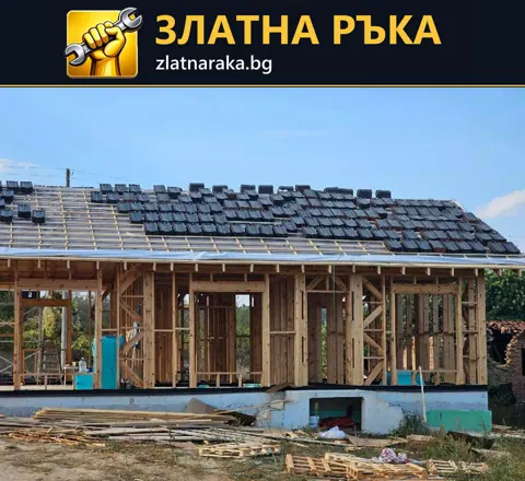 Дървена конструкция на едноетажна къща с открити стени, покривни летви и частично положени тъмни керемиди