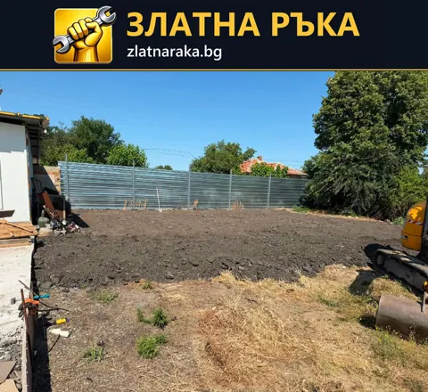 Разчистен и подравнен участък в двор с ограда и строителна машина отстрани.