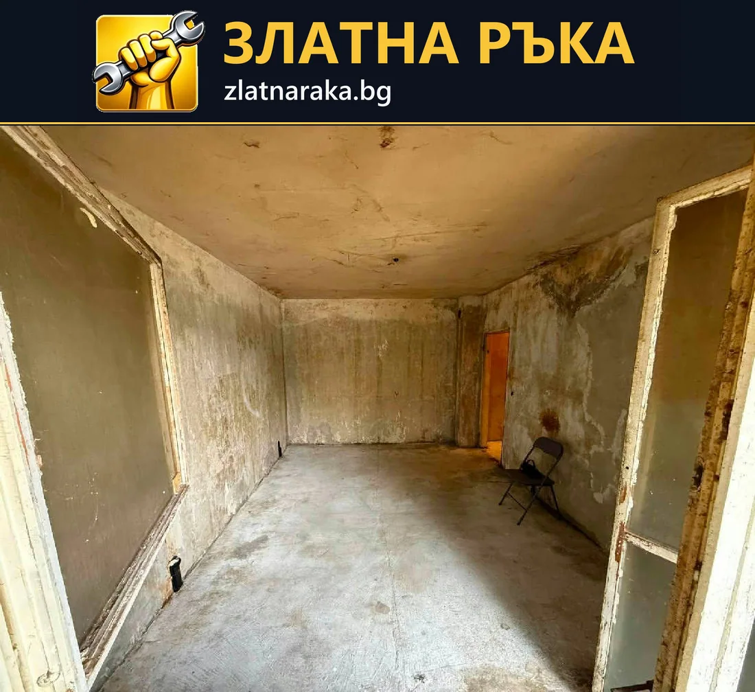 Празно помещение с необработени стени, голям прозоречен отвор и незавършен под.