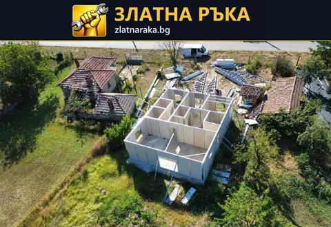 Поглед отгоре към едноетажна постройка с готови светли стени и вътрешно разпределение преди покрива.