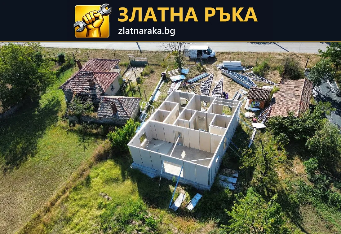 Поглед отгоре към едноетажна постройка с готови светли стени и вътрешно разпределение преди покрива.