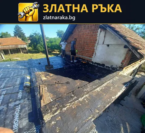 Работници полагат тъмна рулонна хидроизолация върху тераса около тухлена надстройка и излизаща тръба.