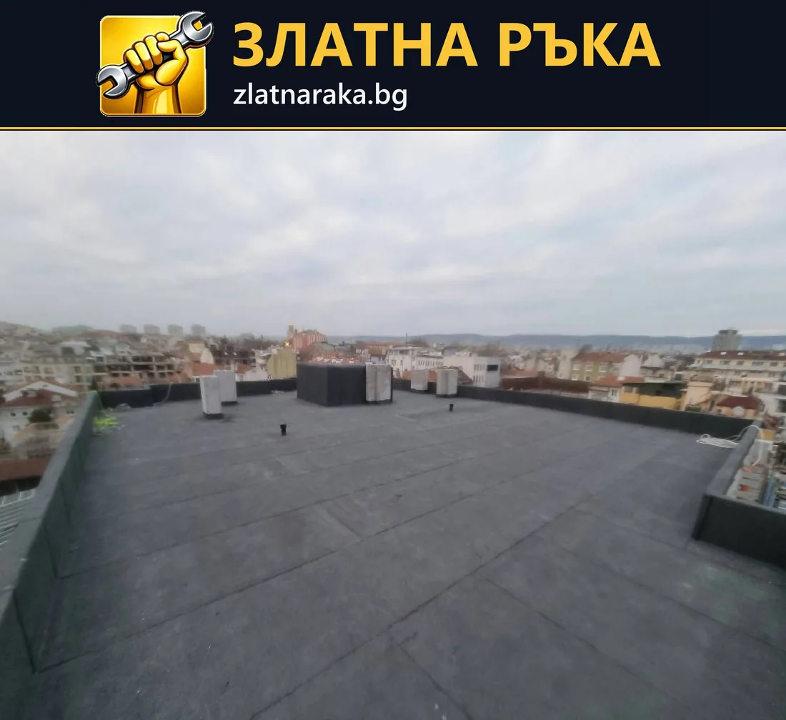 Широк плосък покрив с тъмно рулонно покритие, ниски бордове и няколко излизащи тела