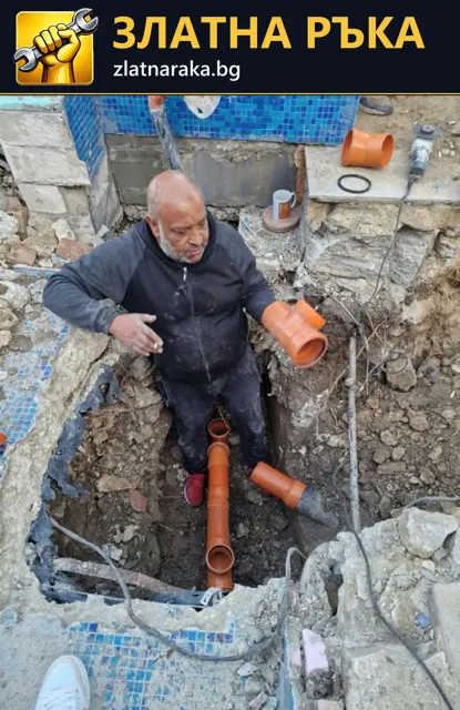 Работник подрежда оранжеви канализационни тръби и разклонения в тесен изкоп до сграда