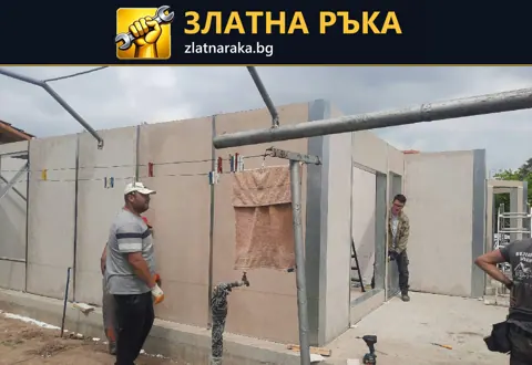 Работници до сглобени светли стенни панели с оформени отвори за врати и прозорци