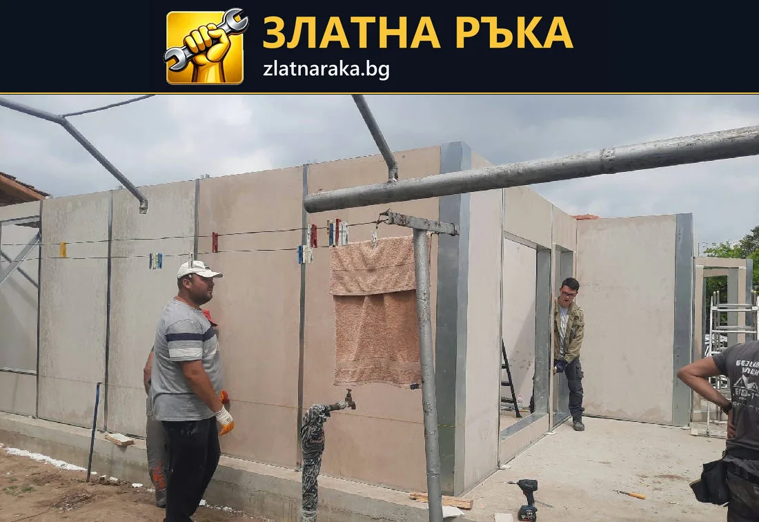 Работници до сглобени светли стенни панели с оформени отвори за врати и прозорци