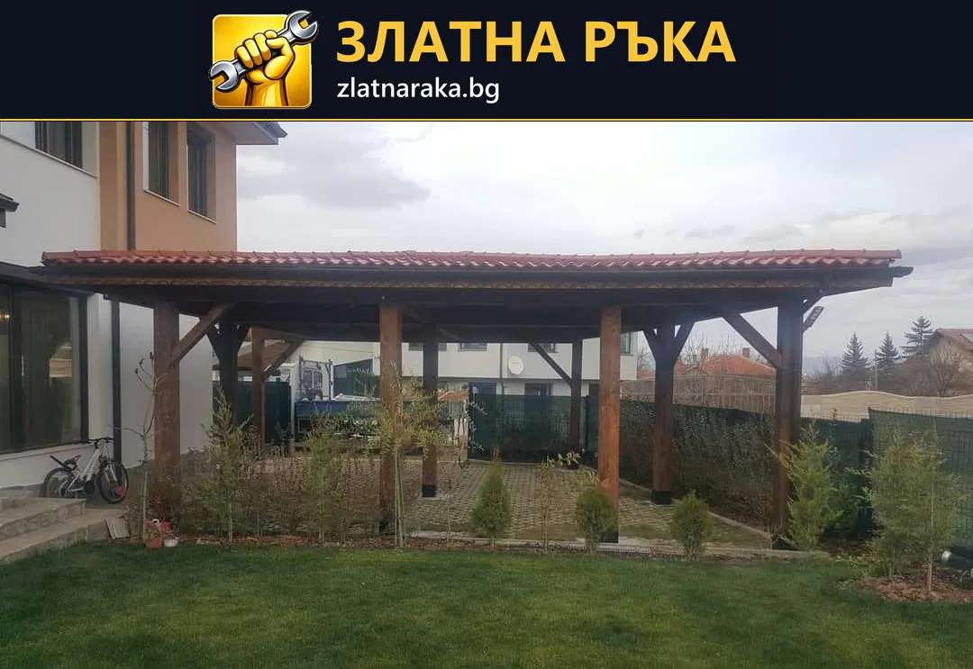 Дървен навес с ред колони и червено покритие се простира край къща над зона до тревна площ
