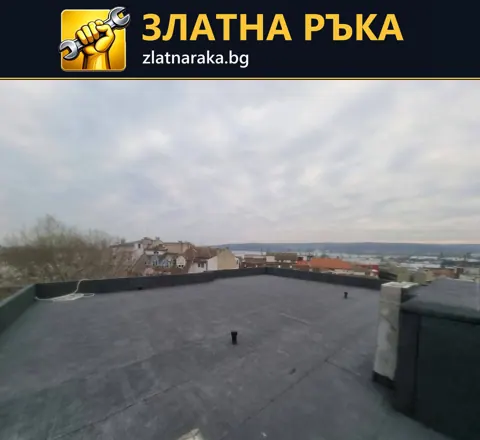 Тъмна непрекъсната покривна площ с ниски бордове, малки вертикални изводи и надстройка вдясно