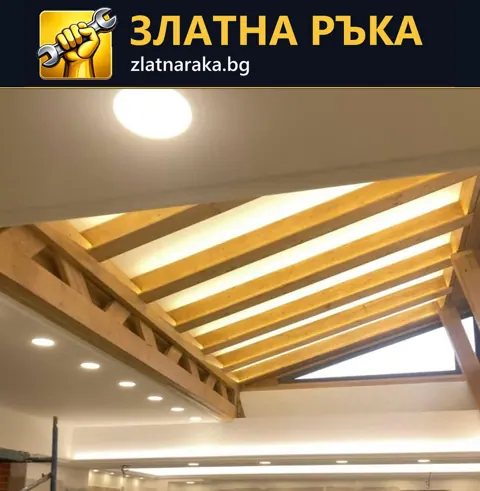Открити дървени греди и светли полета оформят висок скатен таван над бели по-ниски зони с лунички