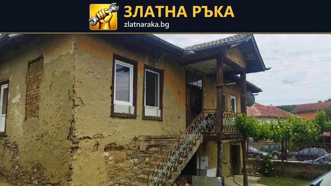 Оронена фасадна мазилка около бели прозорци на стара къща