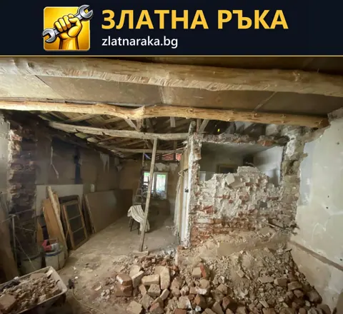 Демонтаж в стара къща с открити дървени греди, оголена тухлена зидария и строителни отпадъци.