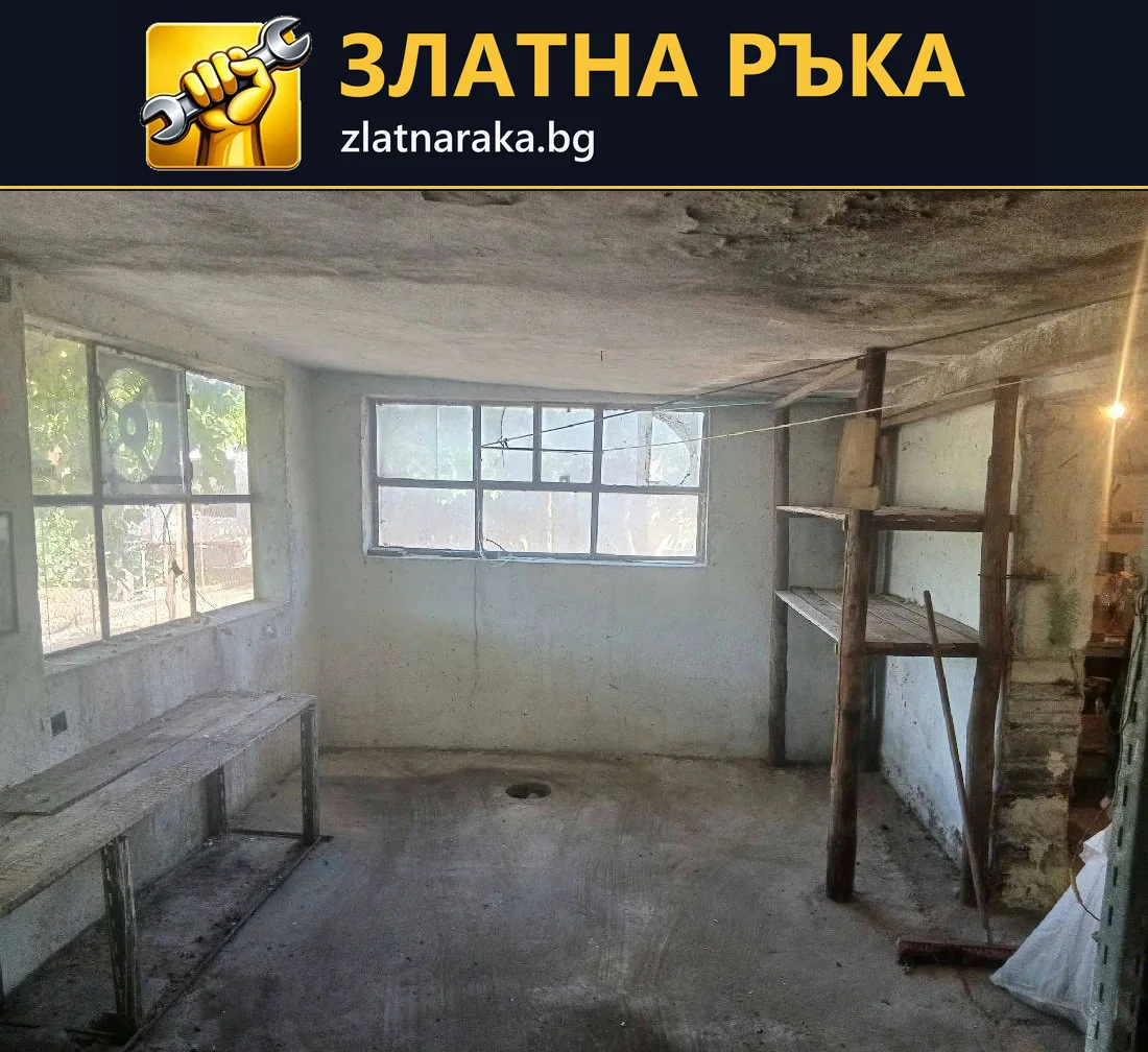Старо вътрешно помещение преди ремонт с неравни стени, износен таван и множество прозорци.