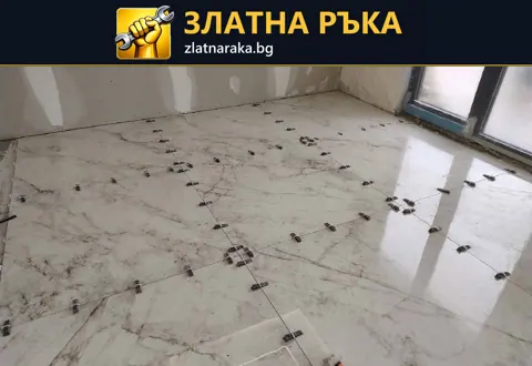 Големи светли подови плочки с тъмни жилки и клипсове по фугите