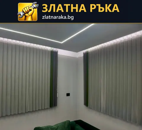 Таван с тънка светеща линия и скрито осветление над сиви вертикални щори.