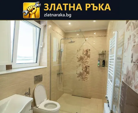 Завършена светла баня с прозорец, цветна декоративна зона при душа и бяла отоплителна лира.