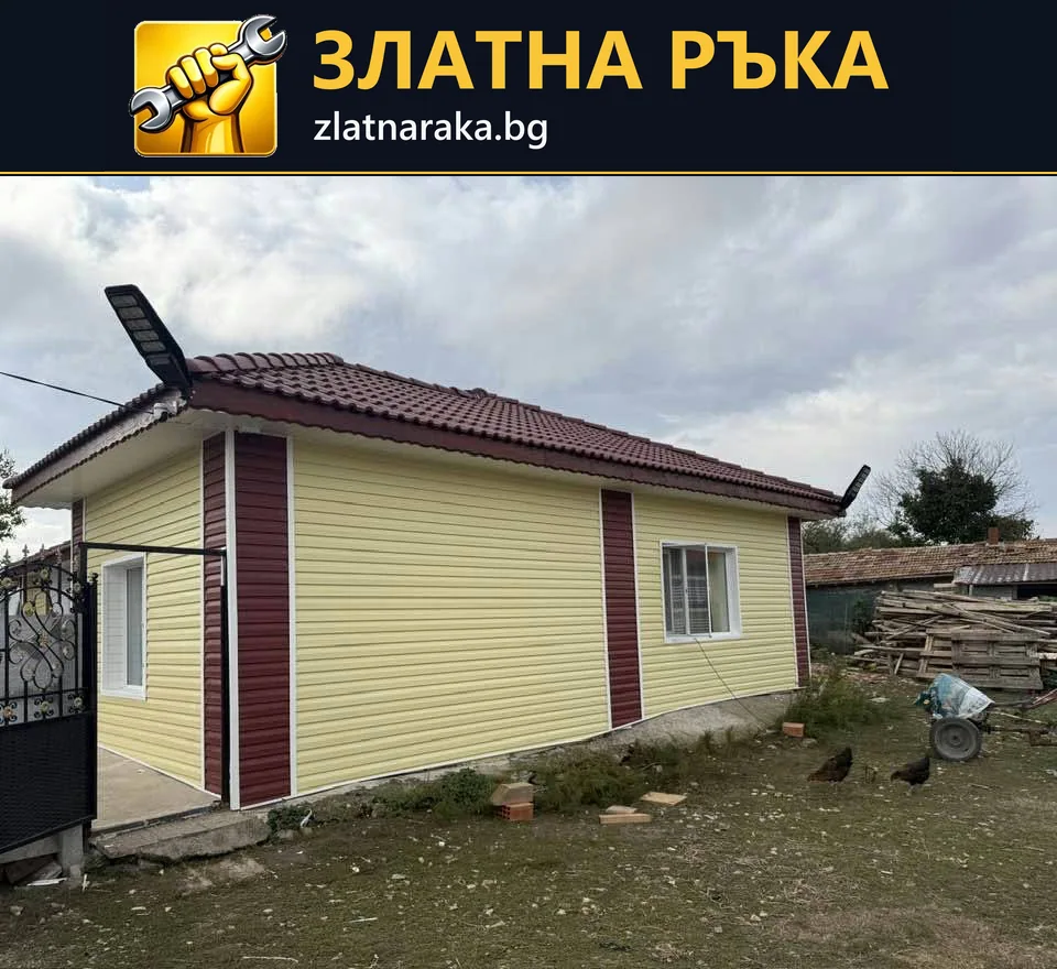 Едноетажна къща със светла хоризонтална фасадна облицовка и тъмни вертикални акценти по ъглите.