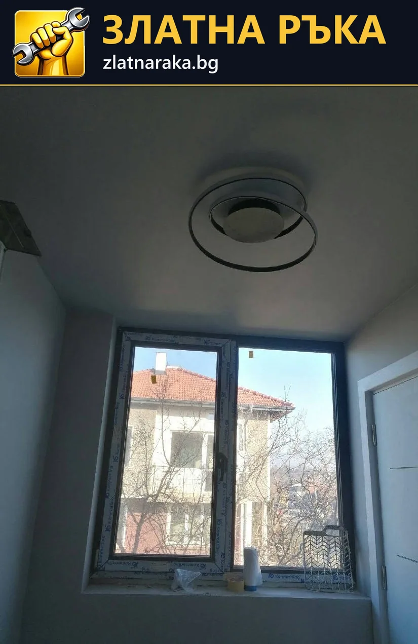 Тясна светла стая с висок двукрилен прозорец и кръгло таванно осветително тяло