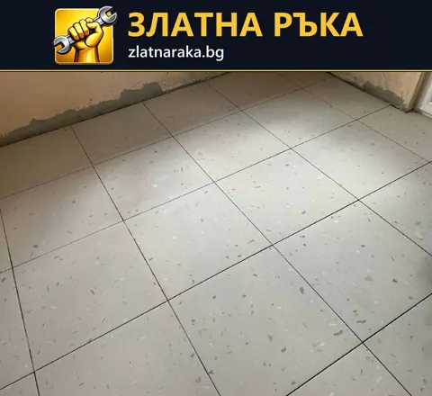 Светла настилка от квадратни плочки с дребни цветни включвания и тъмни фуги