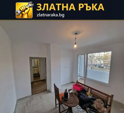 Празно помещение в ремонт с бели стени, голям прозорец и необработена подова основа