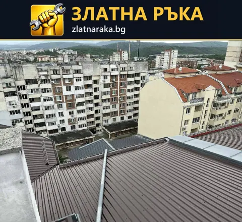 Скатен покрив с тъмни профилирани метални листове и светли обшивки по пресичанията.