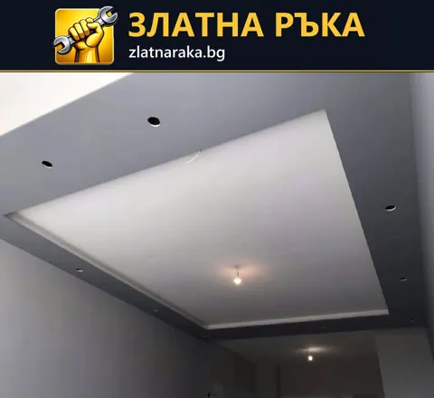 Широк сив таванен борд с отвори за лунички обрамчва светла централна част в стая