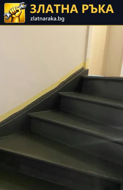 Тъмни стъпала и чела по вътрешна стълба с жълта защитна лента по светлата стена