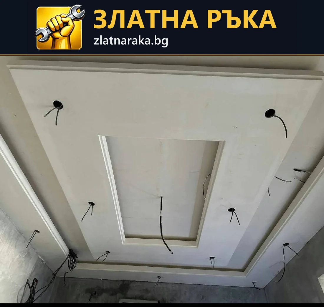 Незавършен бял таван с вложени правоъгълни рамки, кръгли отвори и висящи проводници