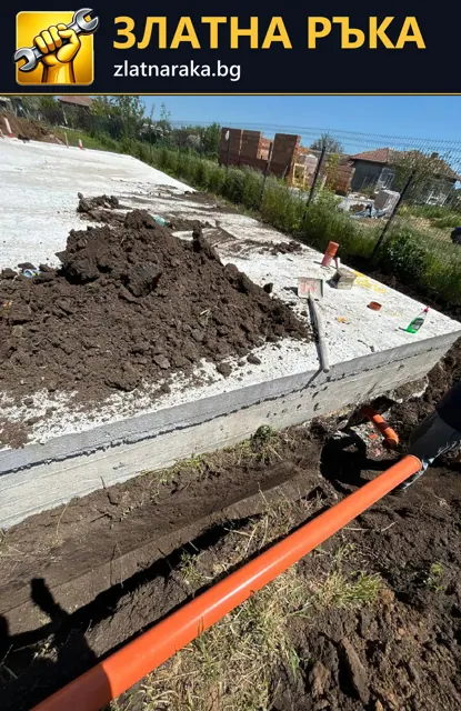 Оранжева канализационна тръба в тесен изкоп до бетонна основа