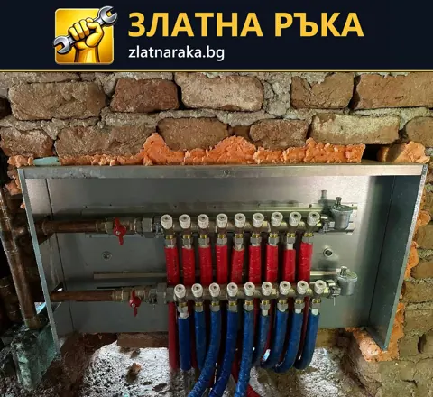 Отворен метален шкаф в тухлена стена съдържа два колектора с множество червени и сини тръбни линии