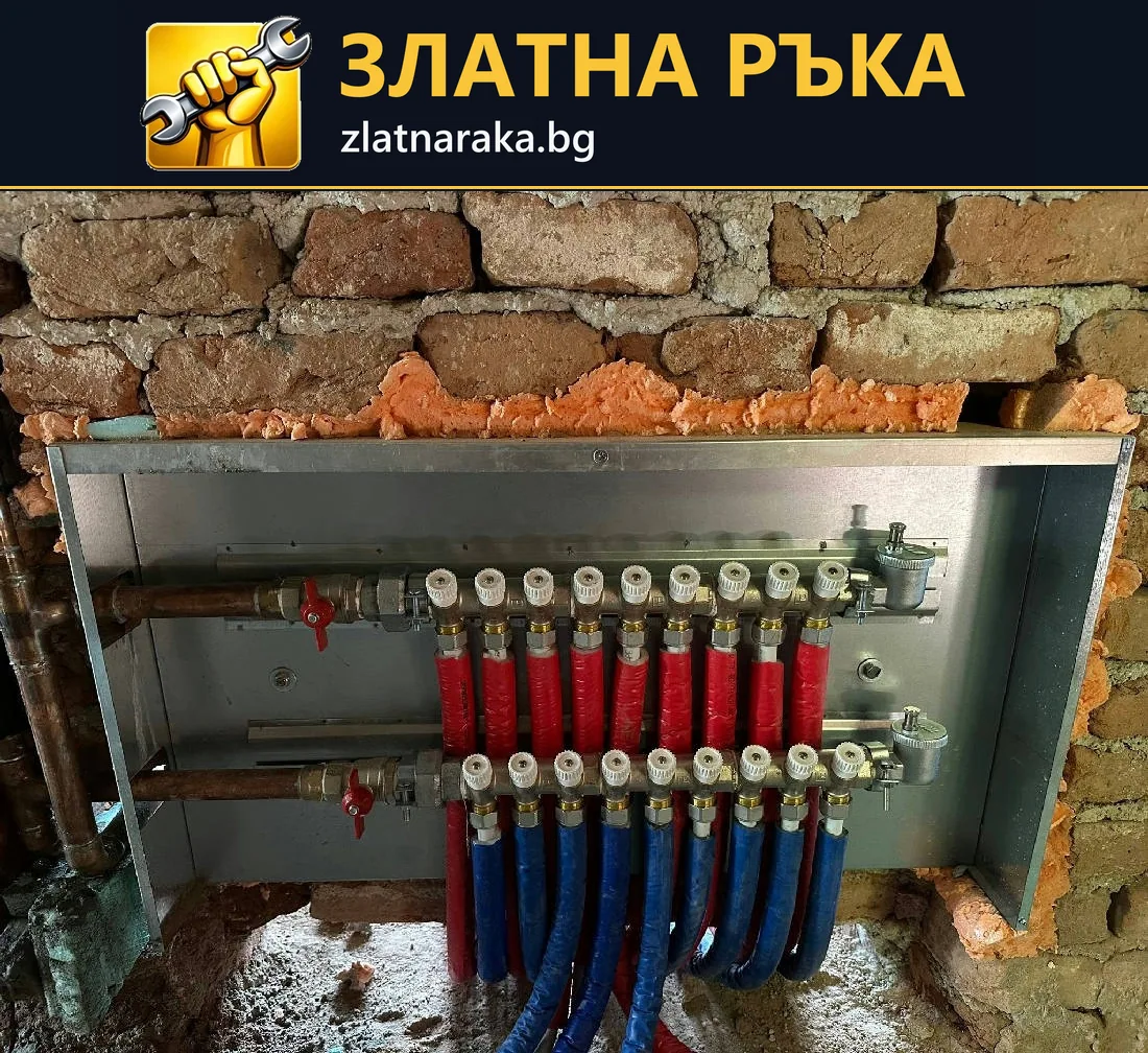 Отворен метален шкаф в тухлена стена съдържа два колектора с множество червени и сини тръбни линии
