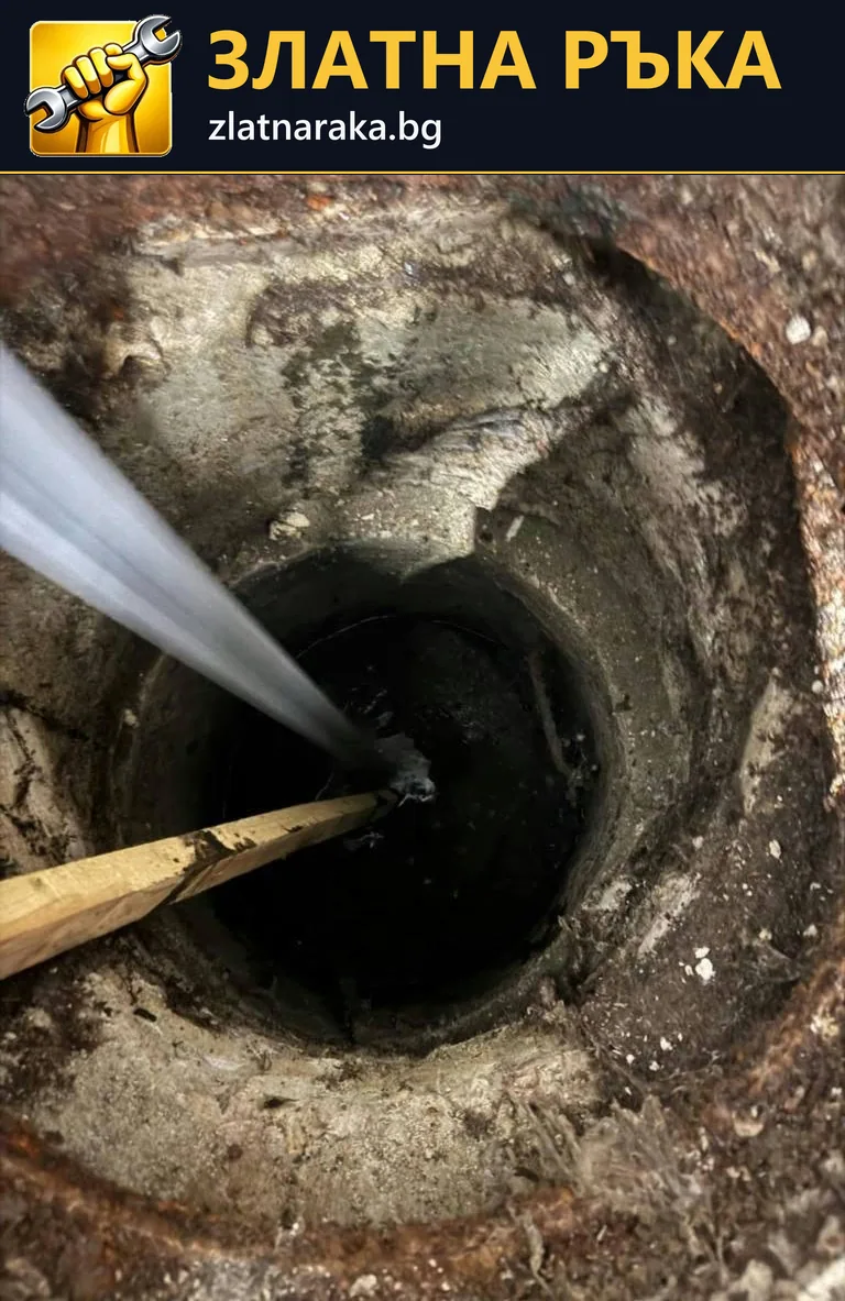 Силна водна струя влиза в тъмна кръгла шахта с открит бетонен ръб